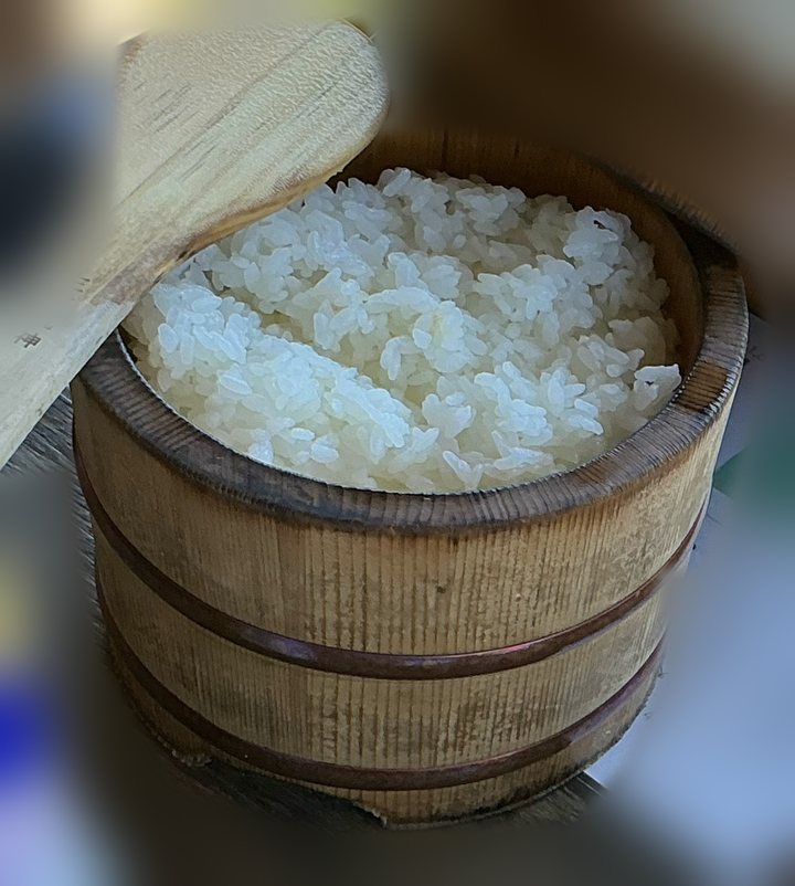 しゃもじを添えた木のおひつに入った、かまど炊きのご飯